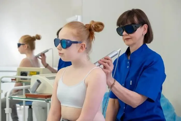 Laseroterapia barku - pacjentka i fizjoterapeutka w okularach ochronnych